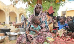 Mariam Djimé Adam, de 33 años, está sentada en el patio de la escuela secundaria de Adre, en Chad. Llegó de Sudán con sus 8 hijos
