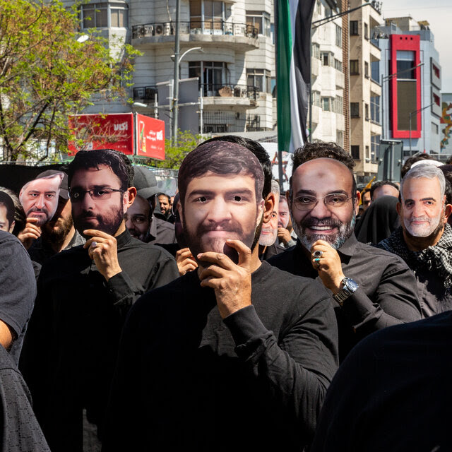 A group of men in Iran wearing masks of Iranian officials killed in Israel’s April attack on Syria.