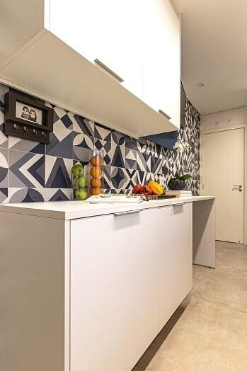 Nesta cozinha com projeto assinado pela arquiteta Gigi Gorenstein e executada pela MCC Arquitetura, o branco do mobiliário SCA Jardim Europa foi vital para destacar o revestimento geométrico aplicado na parede | Foto: Luis Gomes