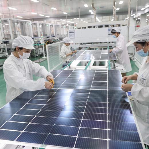 Employees work on solar photovoltaic modules that will be exported at a factory in Lianyungang, in China's eastern Jiangsu province on January 4, 2024. (Photo by AFP) / China OUT