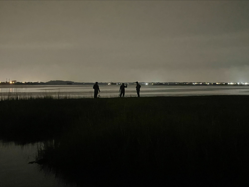 ECO conducting a fishing compliance check after dark with two people near the water