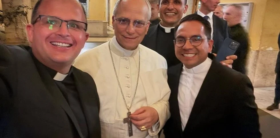 El Papa León XIV, vestido de blanco, con sacerdotes con los que se hizo un selfi en el Vaticano.