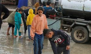 Niños colectando agua durante las primeras lluvias del invierno en Gaza.