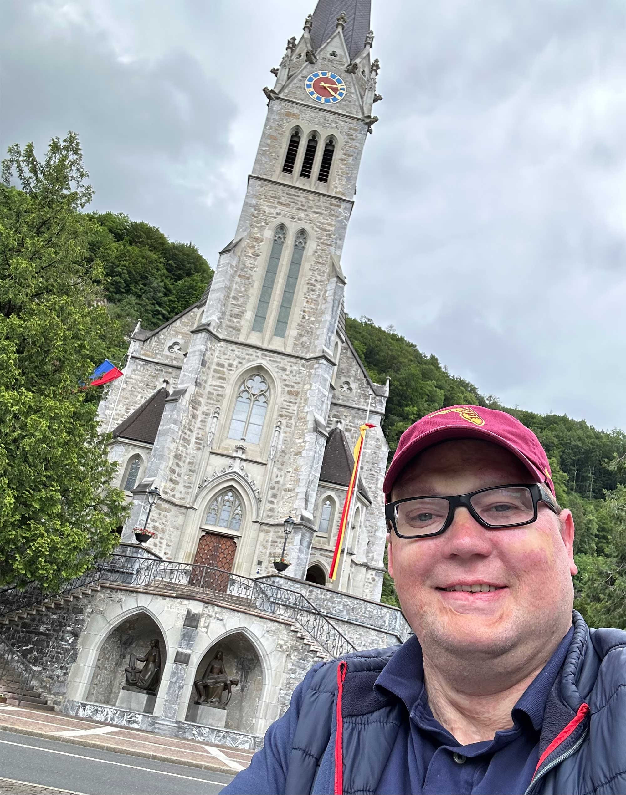 Selfie of John in front of cathedral with trees surrounding it. Selfie of John in front of cathedral with trees surrounding it.