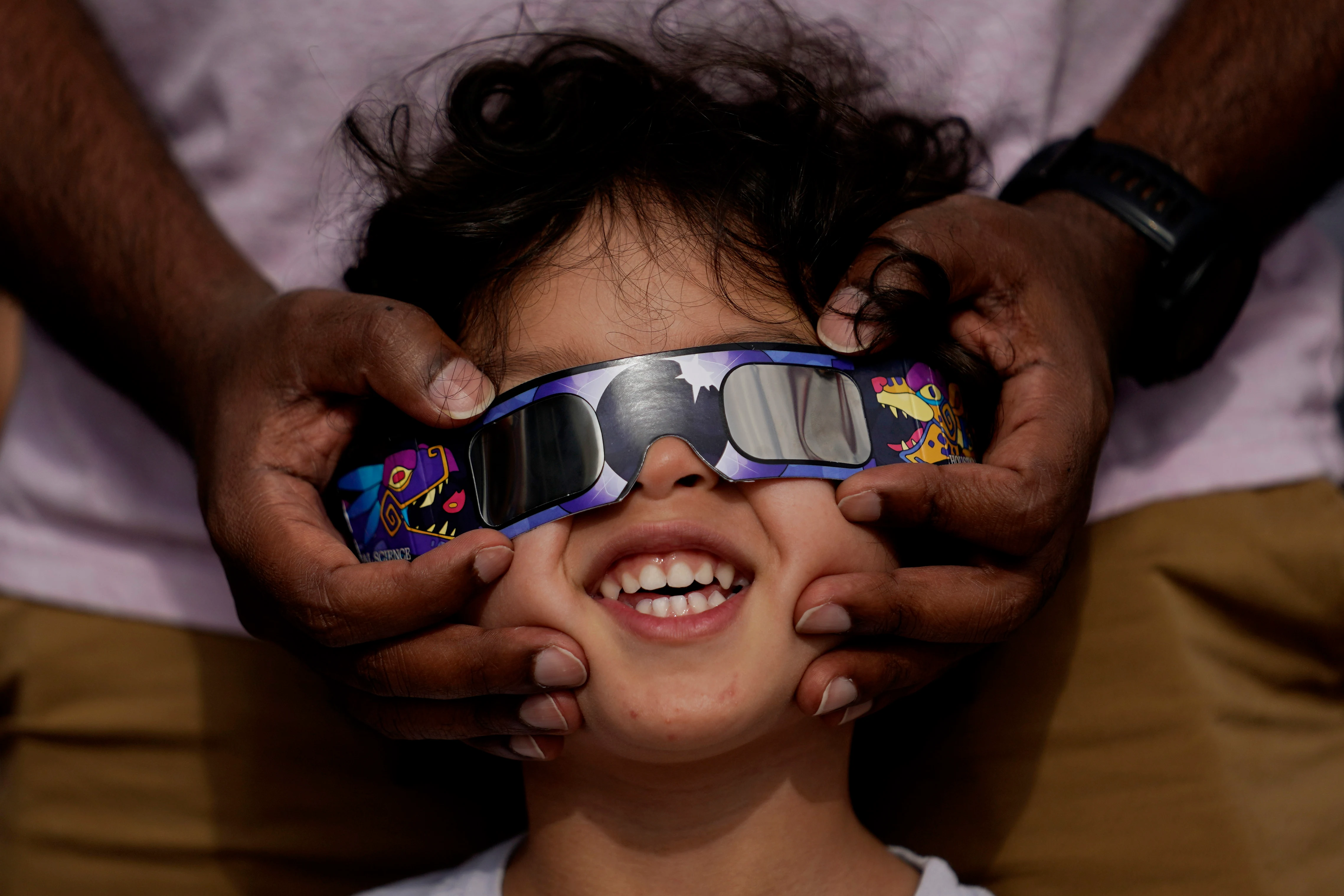 Viewers use special glasses to watch from San Antonio, as the moon moves in front of the sun during a solar eclipse.