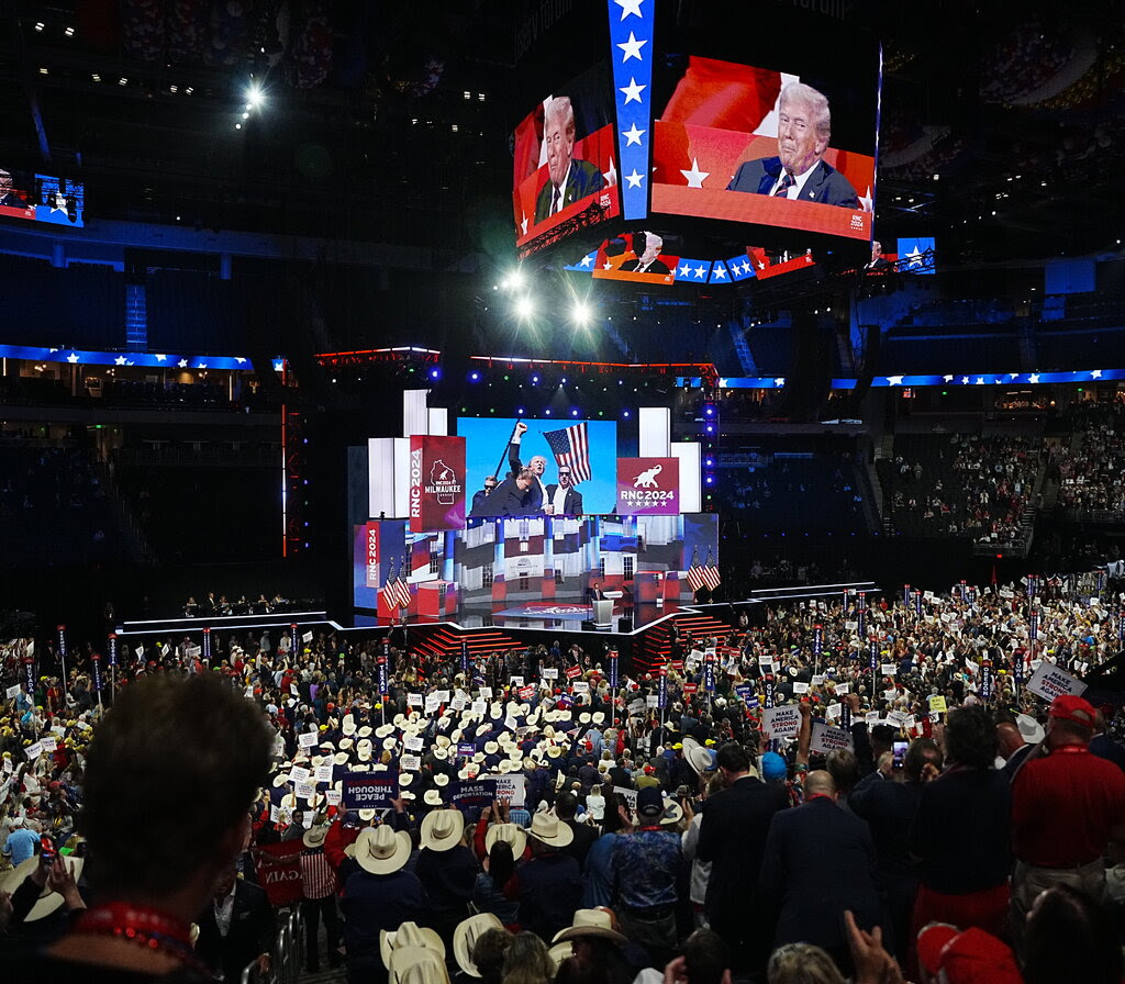 Former President Donald Trump’s face appears on the video board above the crowded arena where the Republican National Convention is being held.