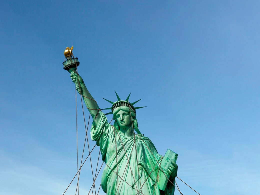 A photo of the Statue of Liberty, tied down by wires.