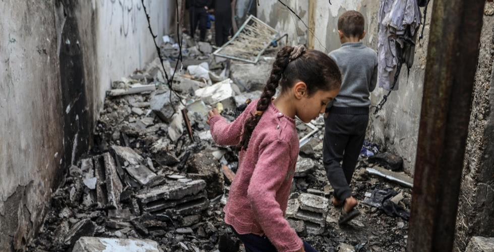Gros plan sur deux enfants au milieu des décombres à Gaza. Ils inspectent les restes d'une maison après une attaque aérienne israélienne dans la ville de Rafah.