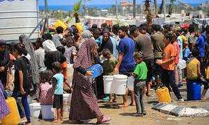 Familias gazatíes recolectando agua de una instalación de UNICEF en Deir al-Balah, Gaza.