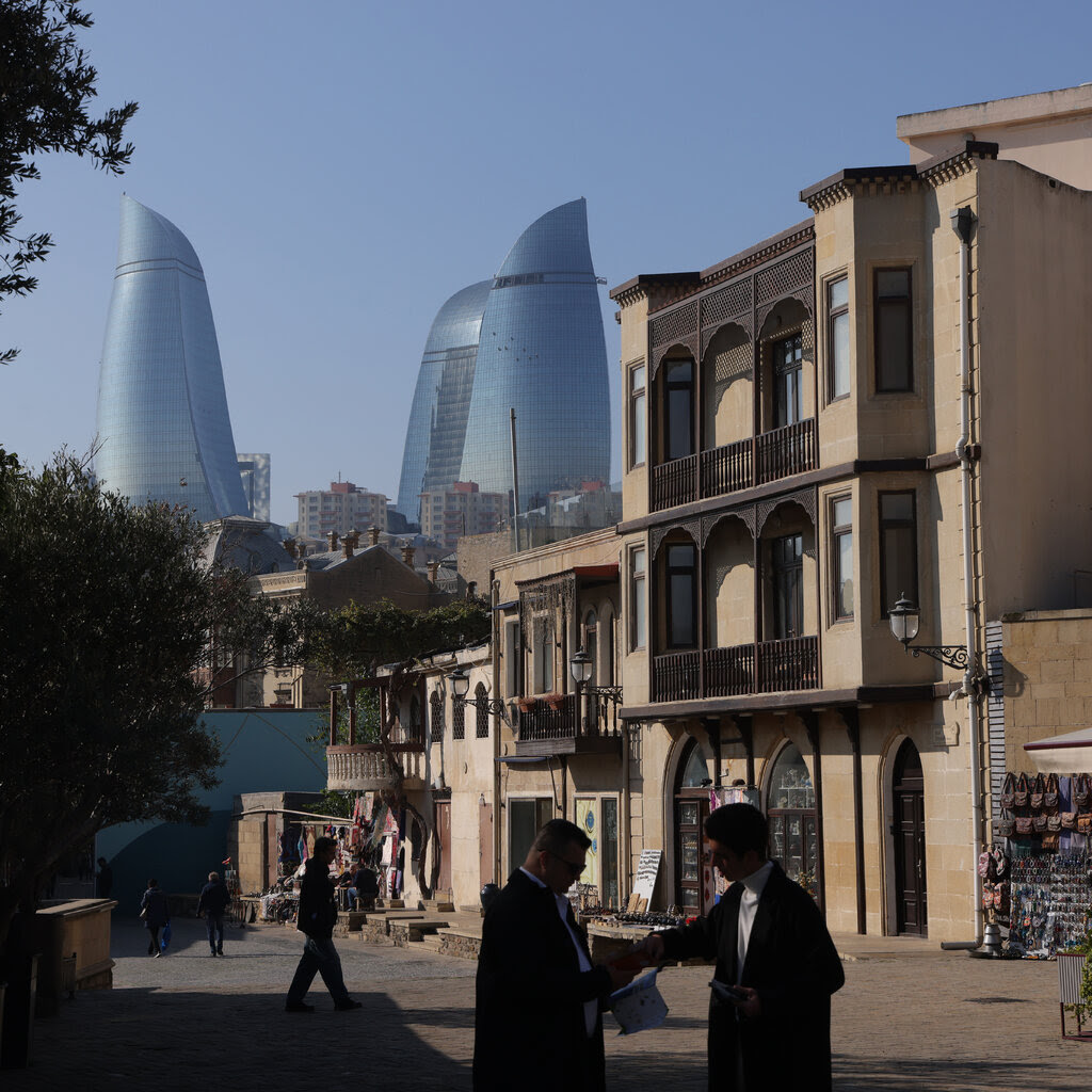 Tall buildings above an older town.