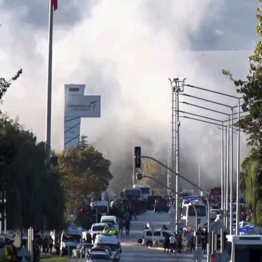 Smoke raises as emergency rescue teams and police officers attend outside Turkish Aerospace Industries Inc. on the outskirts of Ankara, Turkey, Wednesday, Oct. 23, 2024. (IHA via AP)