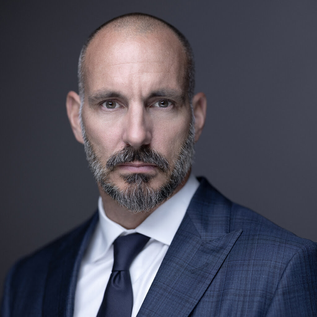 A bearded man in a suit and tie.