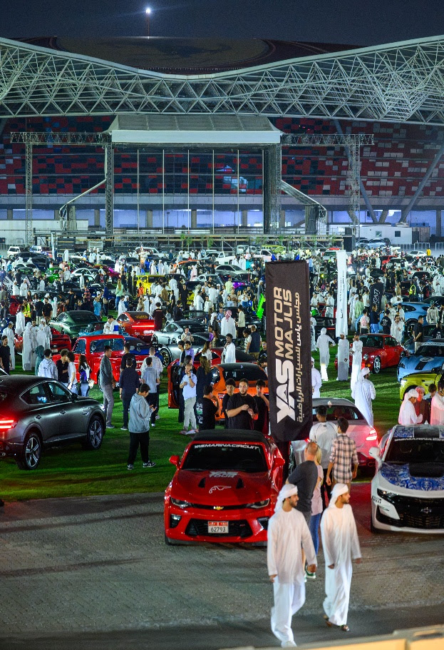 A large crowd of people in a parking lot with carsAI-generated content may be incorrect.