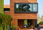 La planta principal está rodeada de grandes ventanas y puertas correderas que permiten que los espacios fluyan hacia varias terrazas y patios.