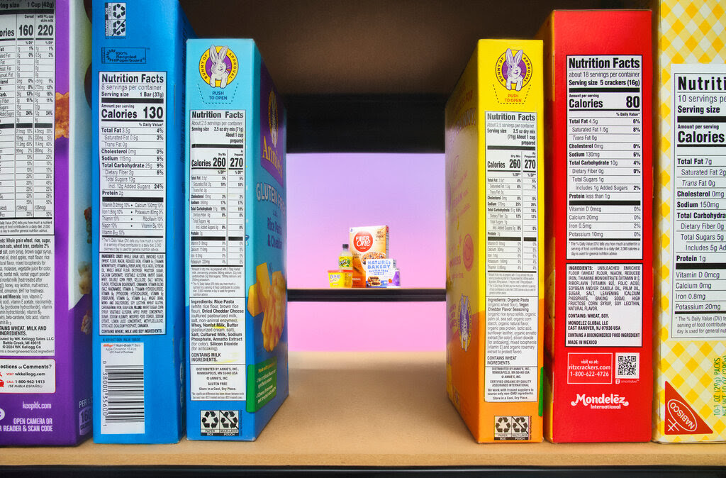 A photo illustration of boxed foods on a shelf with the labels facing outward. There is a gap between the food boxes and beyond the gap on a shelf farther away are an assortment of processed foods. 