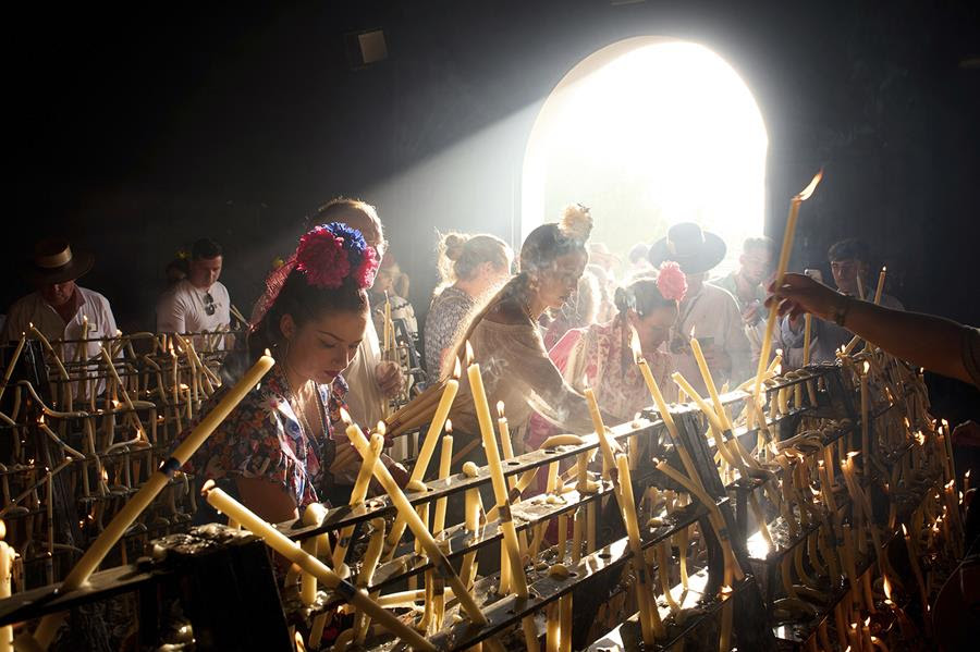 People light candles in a small shrine.