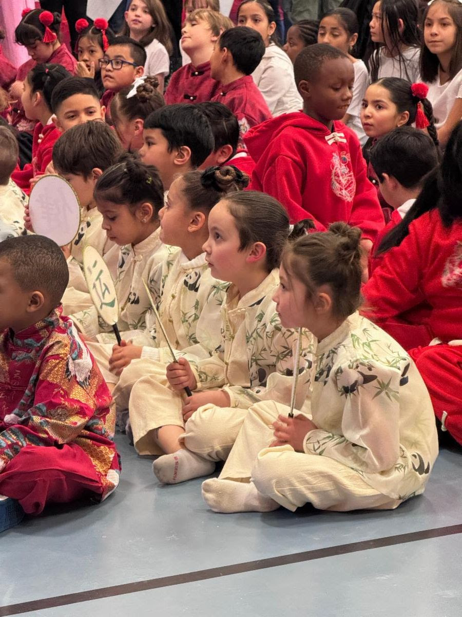 Students sitting while wearing traditional costumes for their Lunar New Year showcase