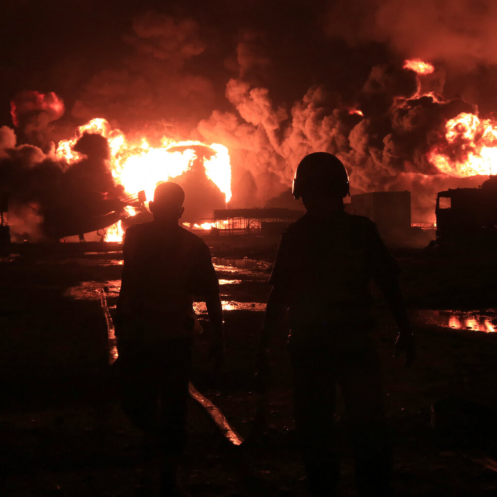 Fire rages at night at an industrial site.