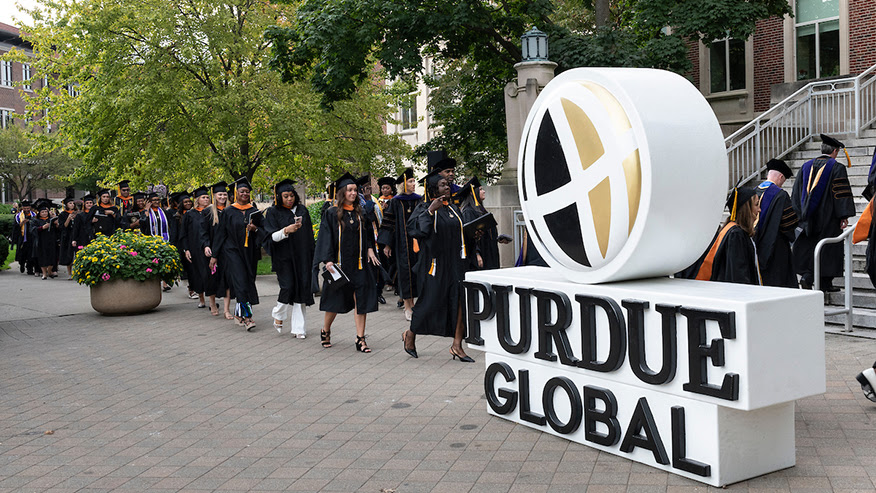 Purdue Global students walking to graduation.