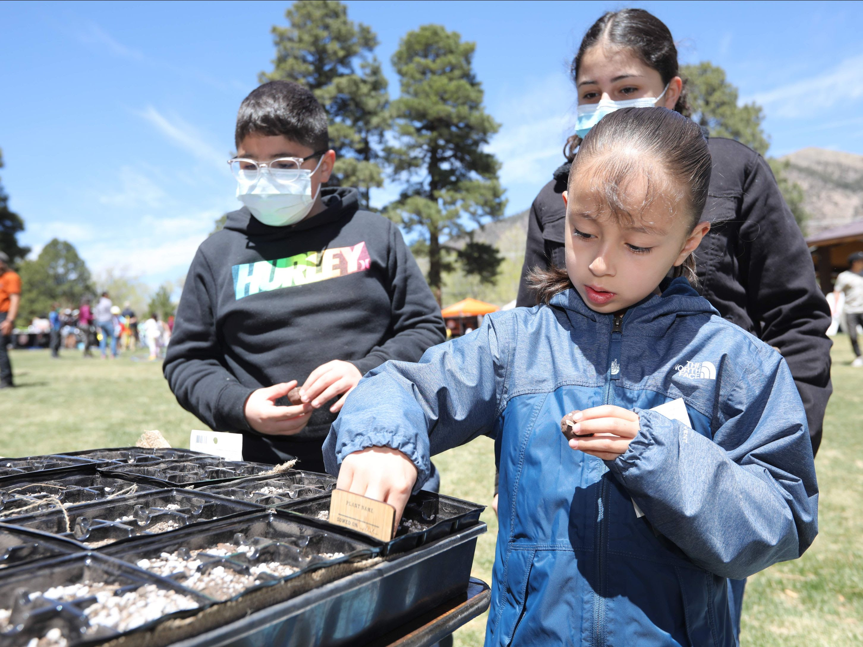 a boy and girl are looking at a soil sample
