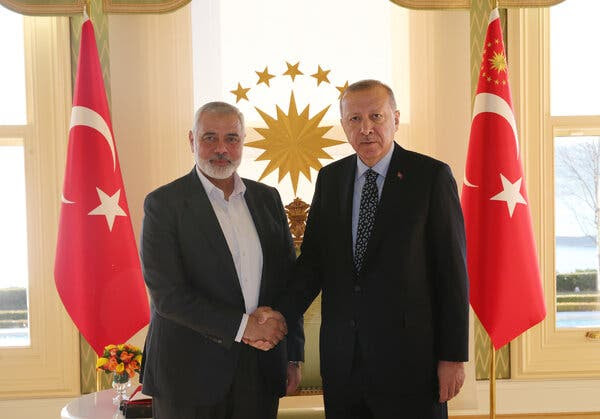 President Recep Tayyip Erdogan of Turkey, right, shakes hands with Ismail Haniyeh, Hamas’s political chief. The are flanked by two Turkish flags.