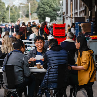 Woman smiling at Farmers Market stall.