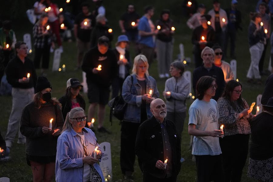 A gathering of people holding small candles at the Say Their Names Cemetery on the five-year anniversary of George Floyd's death.