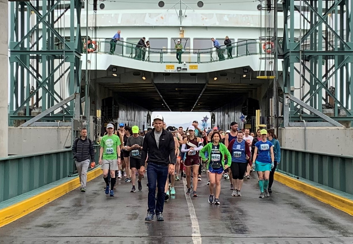 Several race participants walking off a ferry's car deck
