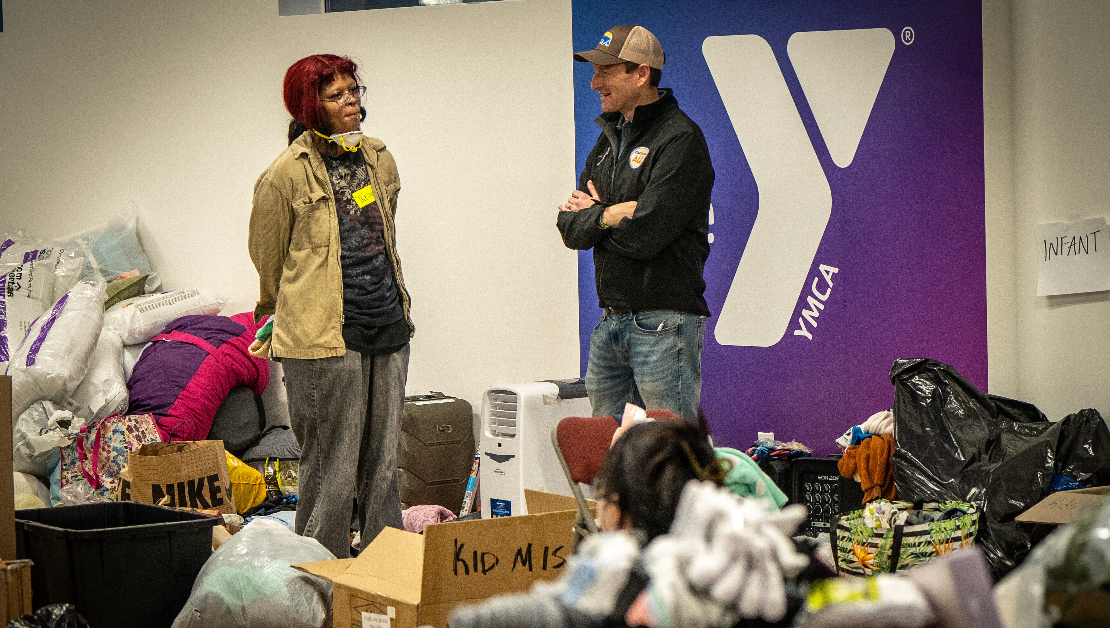 California Chief Service Officer Josh Fryday chats with a volunteer at the YMCA helping with spring clothes.