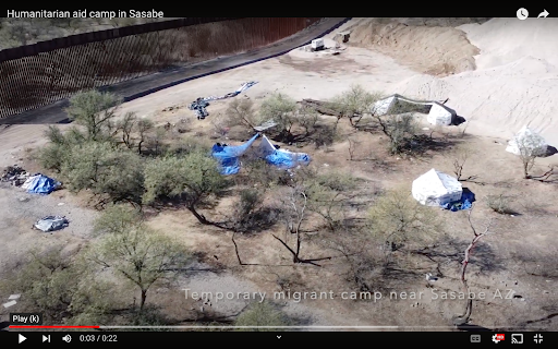 Immigrant camp near the border with tarps and tents among the trees