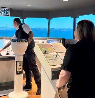 Two people in a ferry wheelhouse simulator