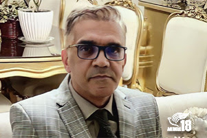 Pastor Nasser Navard Gol-Tapeh is in a suit and seated on a sofa.