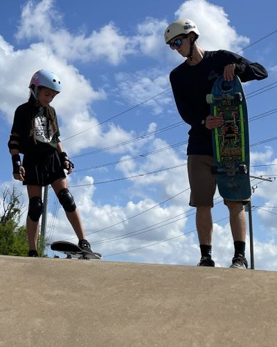 Child learning to skateboard with SK8 Charleston instructor