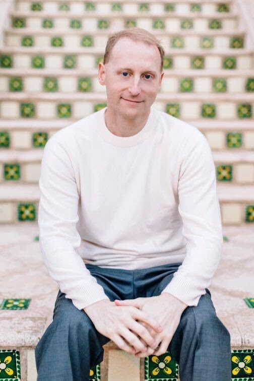 George Ackerman is shown seated on a bench in this photograph.