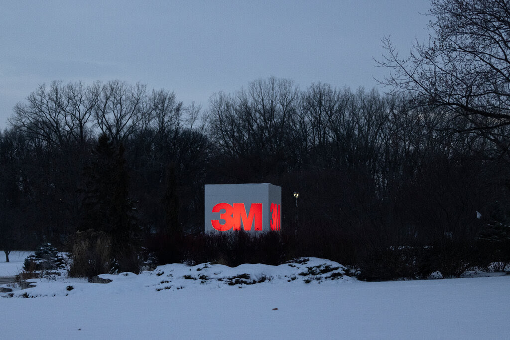 A view of a large blocky sign bearing the 3M logo on a winter evening.