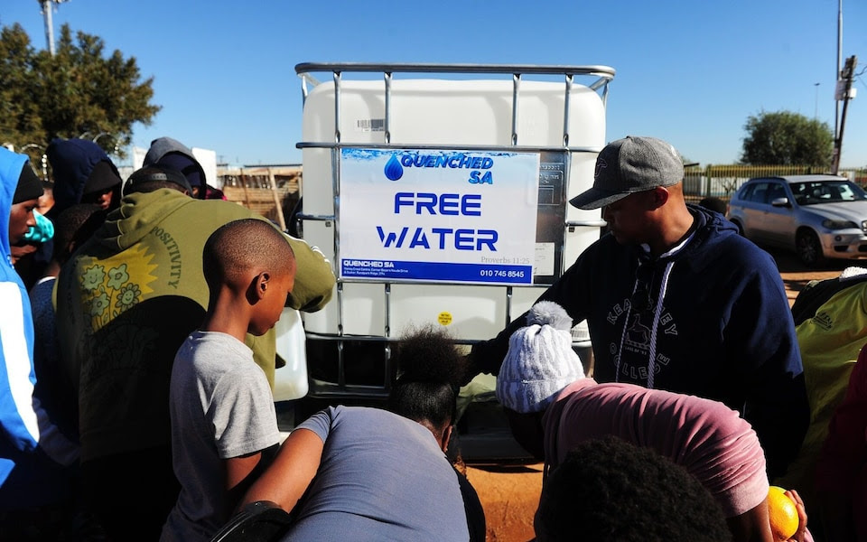 Residents queue for water delivered by an NGO in Hammanskraal, South Africa