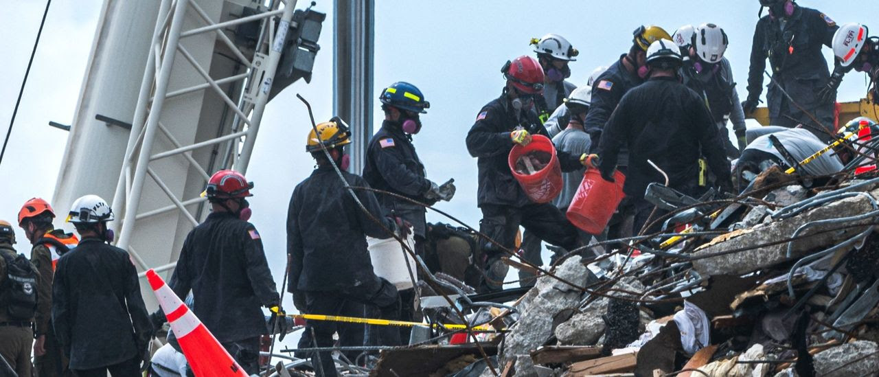 First responders picking their way through the rubble of the Florida condo collapse