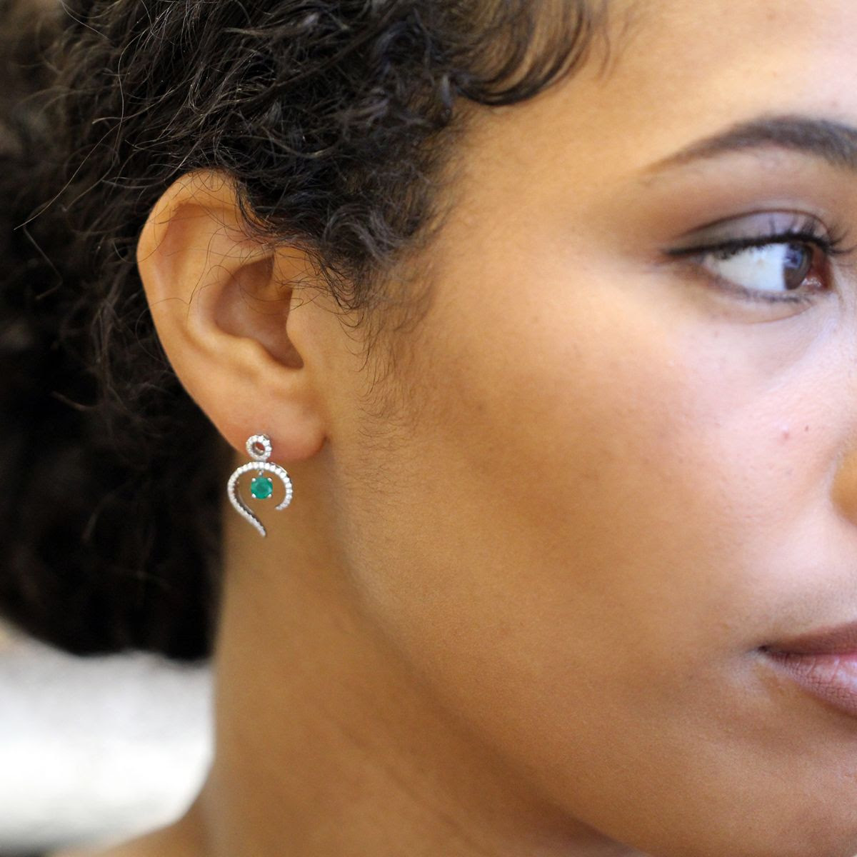 Model wears emerald and diamond drop earrings by ronan campbell at designyard contemporary jewellery dublin ireland 