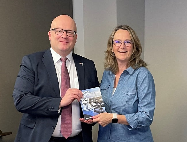 Two people posing for a photo holding up a book titled "Finnish Solutions for Smart Ships"