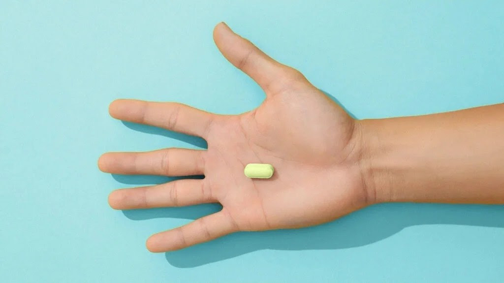 outstretched hand with yellow pill on light blue background