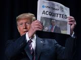President Donald Trump holds up a newspaper with the headline that reads &quot;ACQUITTED&quot; at the 68th annual National Prayer Breakfast, at the Washington Hilton, Thursday, Feb. 6, 2020, in Washington. (AP Photo/ Evan Vucci)
