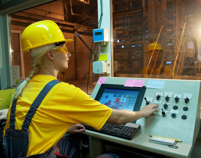 A factory worker at a control panel.