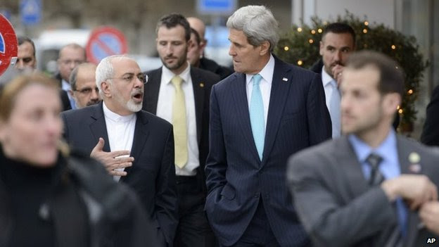 Mohammad Javad Zarif and John Kerry speak to each other while walking through Geneva on 14 January 2015