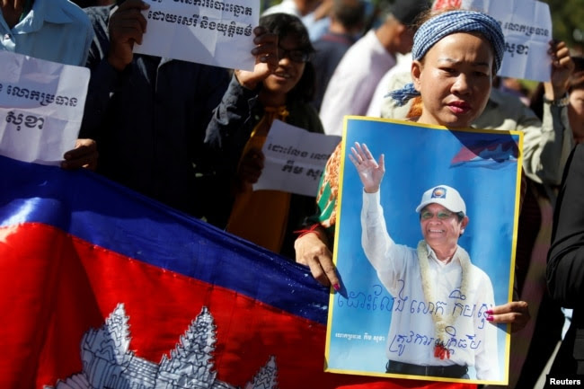 FILE - Supporters of Kem Sokha, leader of the Cambodia National Rescue Party, stand outside the Appeal Court during a bail hearing for the jailed opposition leader in Phnom Penh, Cambodia, Sept. 26, 2017.