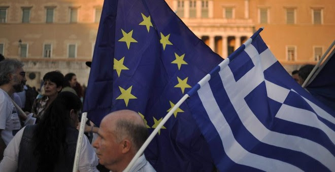 Un manifestante ondea una bandera de la Unión Europea y de Grecia durante una manifestación a favor de la zona euro en Atenas. EFE