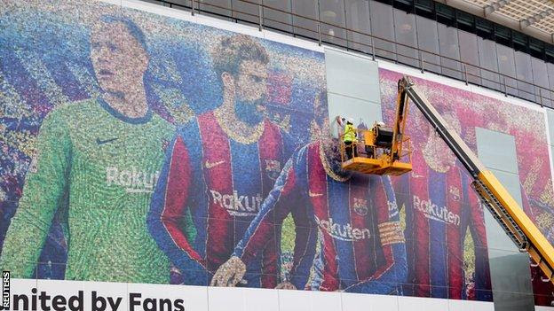 A picture of Lionel Messi is taken down outside the Nou Camp