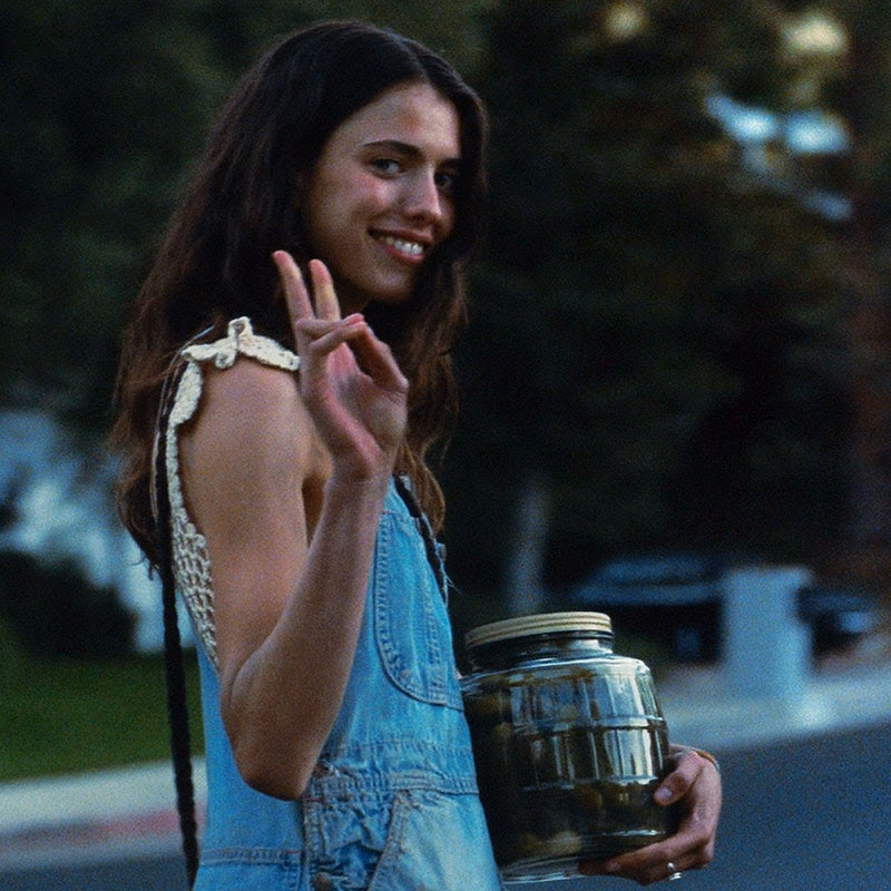Margaret Qualley in %22Once Upon a Time in Hollywood%22 holding a jar and smiling 