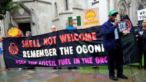 People holding a banner that reads Shell not welcome, remember the Ogoni, keep fossil fuel in the ground