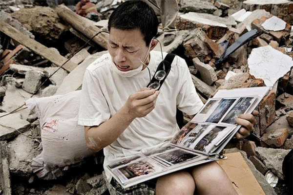 Người đàn ông không kiềm được nước mắt sau khi tìm thấy chiếc album ảnh của gia đình mình sau trận động đất khiến cho ngôi nhà hoàn toàn bị phá hủy.