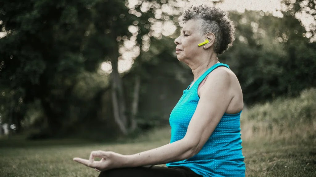 a woman practices mindfulness meditation outdoors